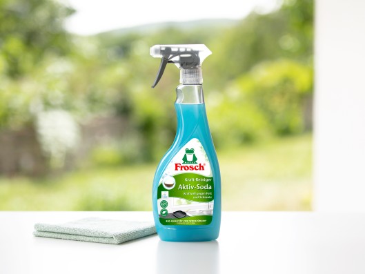 A Frosch power-cleaner active soda trigger bottle stands next to a cloth